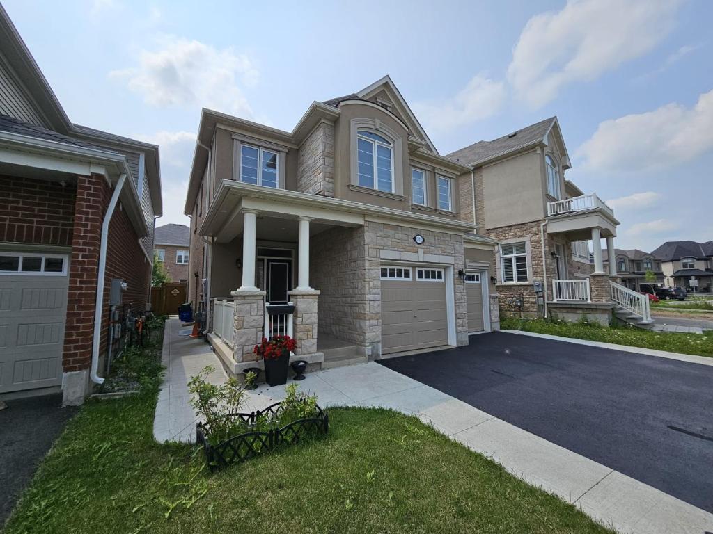 a large house with a driveway and a garage at Exclusive 2 BR Furnished Apartment in Milton Ontario Canada in Milton