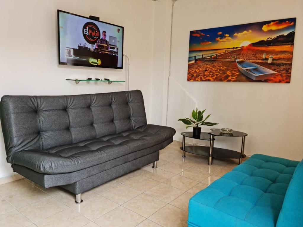 a living room with a couch and a tv at NEW COZY APARTMENT 101 IN MEDELLIN, ENVIGADO in Envigado