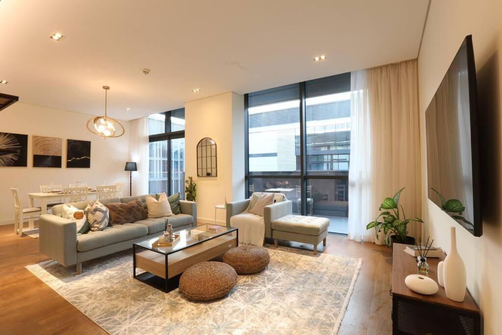 a living room with a couch and a table at Manzil - Sleek 2BR nr Downtown & Dubai Mall in Dubai
