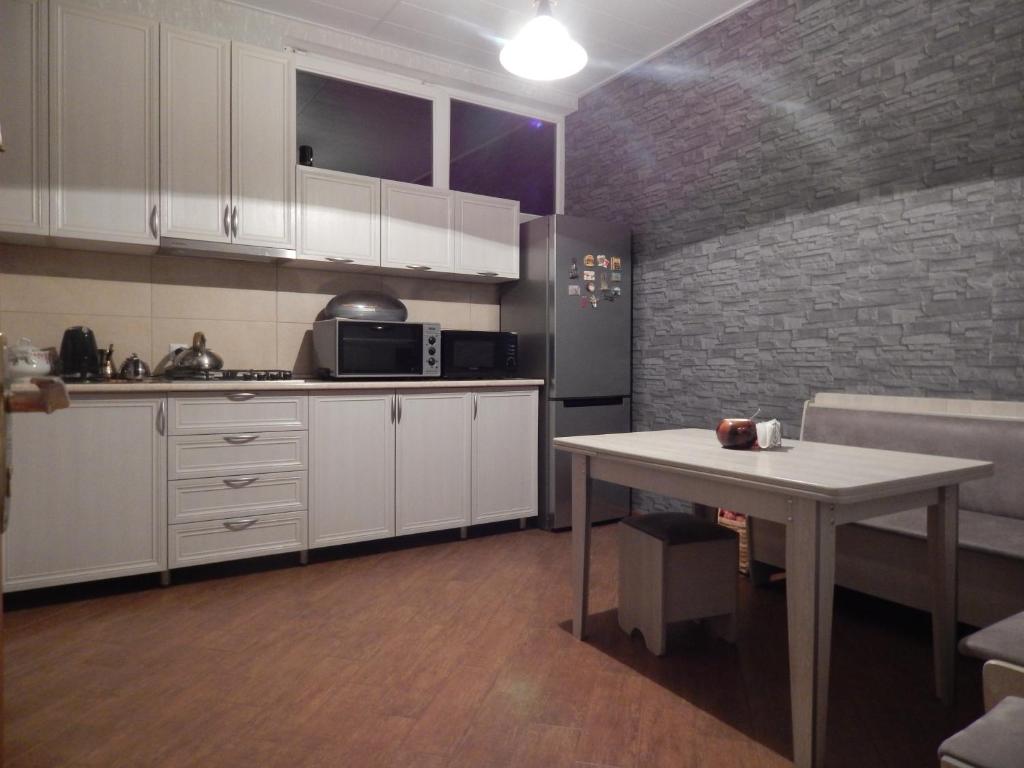 a kitchen with a table and a brick wall at When in Tbilisi in Tbilisi City