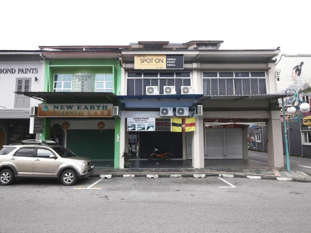 un coche aparcado en un estacionamiento frente a un nuevo banco en Amida Point, en Kuching