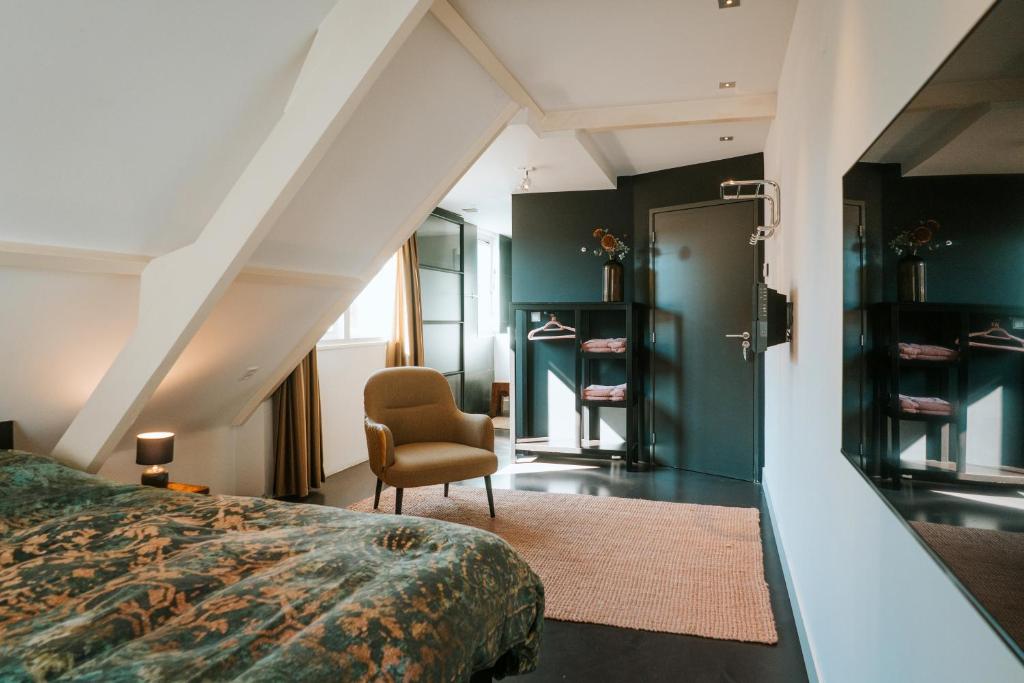 Texels Goud Deluxe Suites في دن بورخ: غرفة نوم بسرير وكرسي