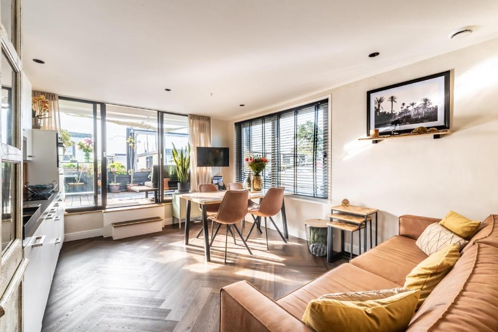 a living room with a couch and a table at Beautiful Water Villa, near Schiphol and Amsterdam in Aalsmeer