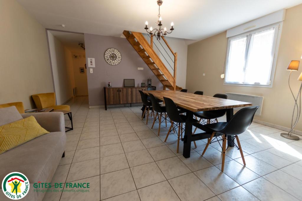 a dining room and living room with a table and chairs at L&#39;Appart de La Goutte d&#39;Or in Avize