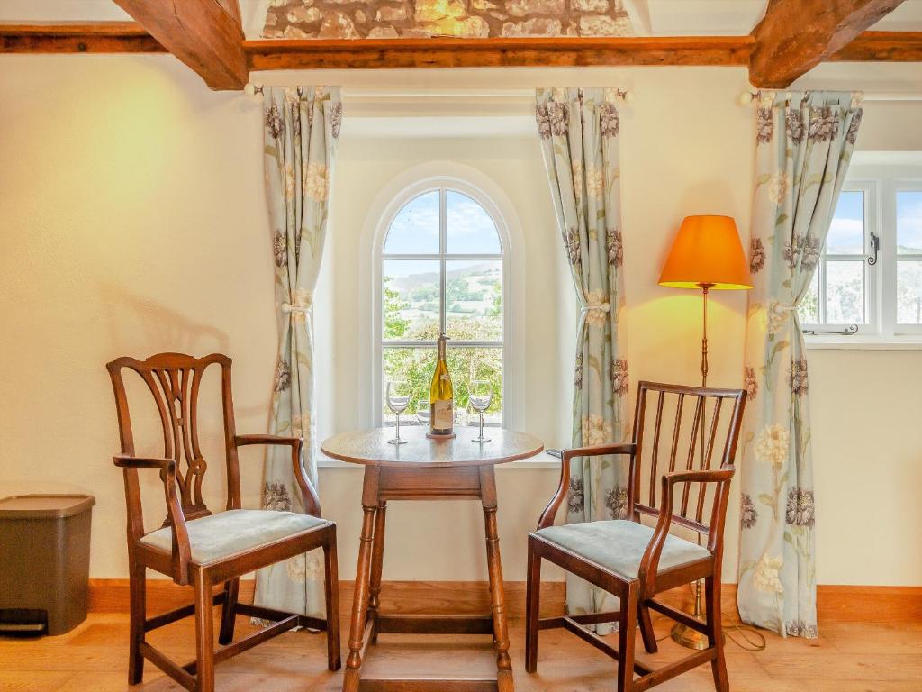 a dining room with a table and chairs and a window at The Chapel - Uk45026 in Gilwern