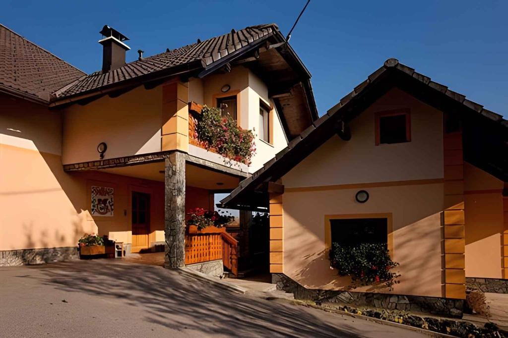 un bâtiment avec des fleurs sur son côté dans l'établissement Houses and Apt in Smarjeske Toplice Kranjska Krain 26042, à Smarjeske Toplice