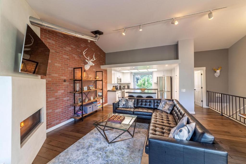 a living room with a couch and a brick wall at #521- Luxury Remodeled, Mid-Town Condo in Mammoth Lakes