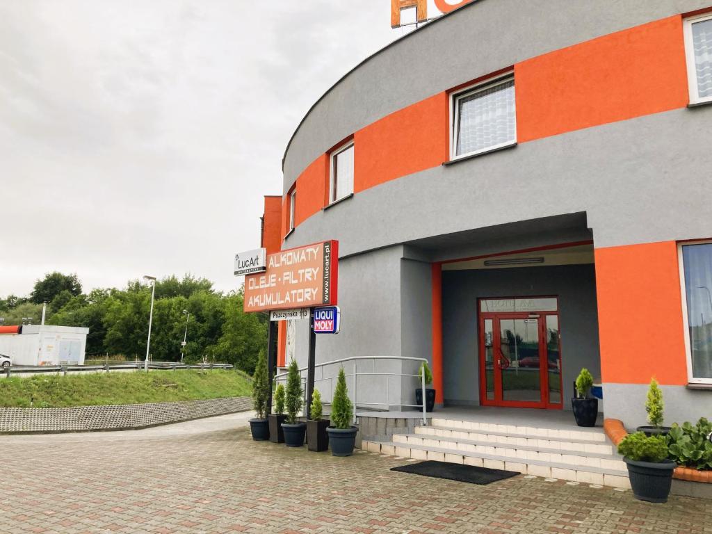 ein orangefarbenes und graues Gebäude mit Pflanzen davor in der Unterkunft Hotel Ava in Gliwice