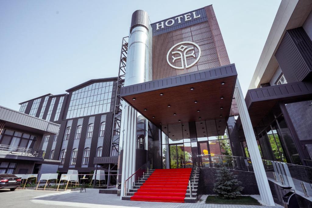 un hotel con una escalera roja frente a un edificio en Tauke Khan Plaza, en Shymkent