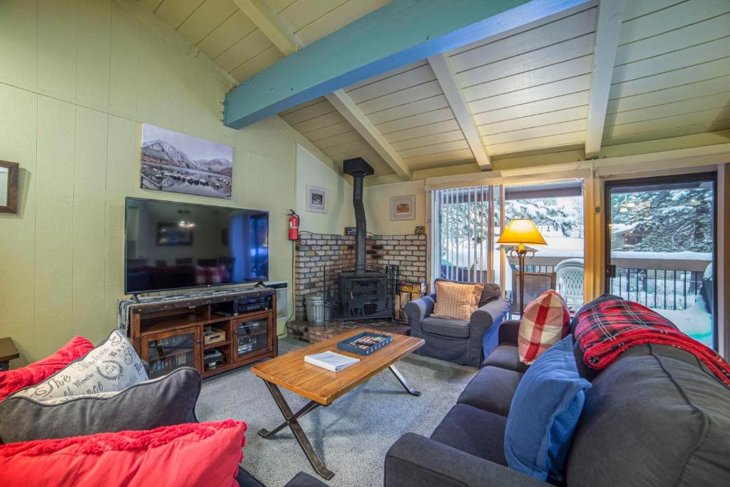 a living room with couches and a tv and a table at #469 - Pet-Friendly Mountain Condo, Pool & Spa in Mammoth Lakes