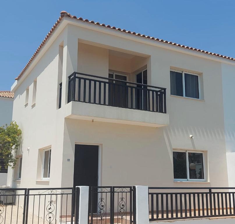 Casa blanca con balcón negro en The T Villa, en Protaras