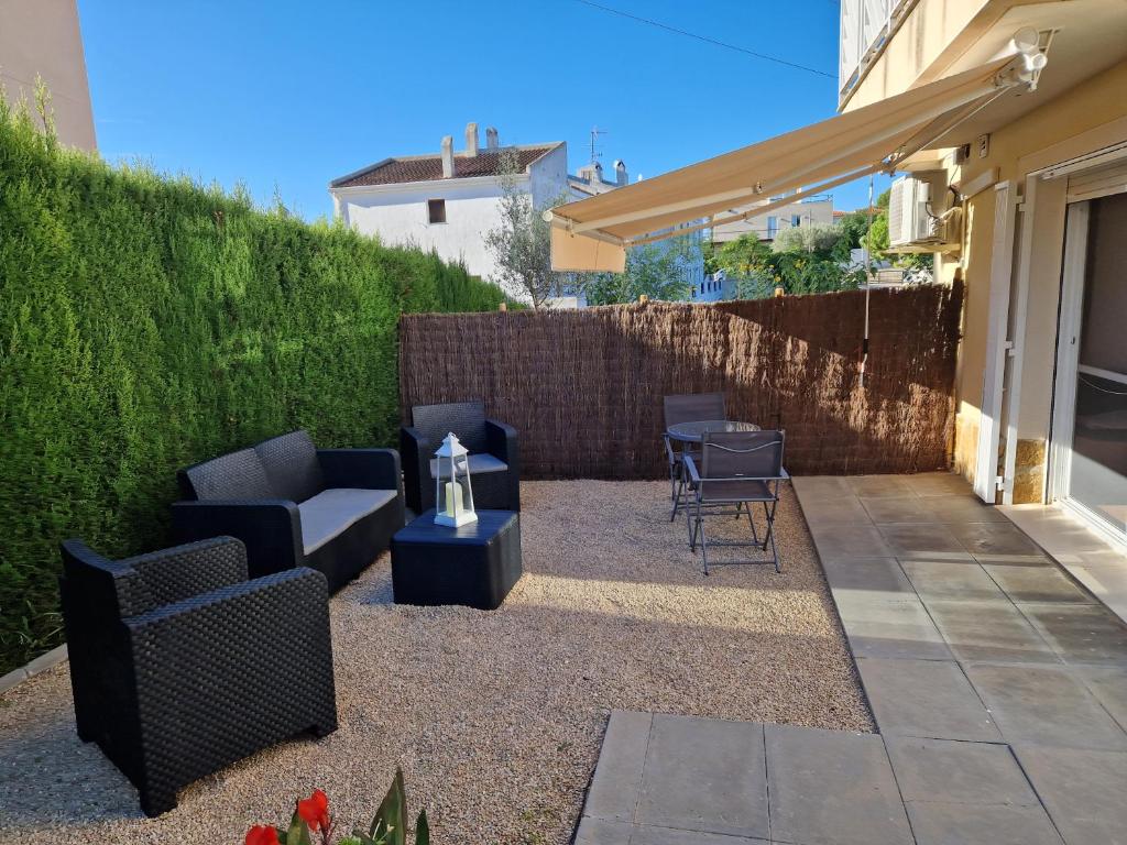 a patio with couches and a table and chairs at Apartament Ca la Rosa in L'Ampolla