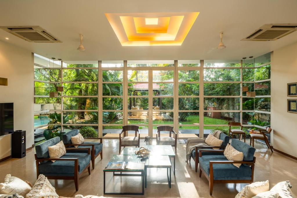 uma grande sala de estar com sofás e uma mesa em Elivaas Dahlia Luxe 4BHK Villa with Pvt Pool near Baga em Arpora