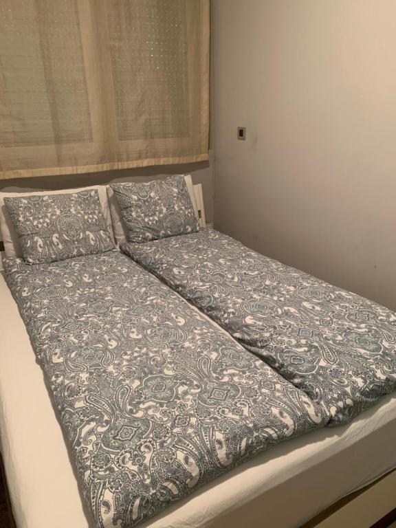 a bed with a blanket and pillows on it at Apollo Apartaments in Zagreb