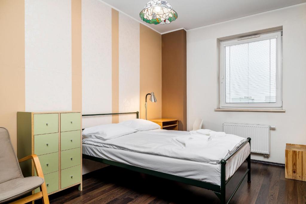 a bedroom with a bed and a chair and a window at Apartamenty Platinum Inowroclawska Wrocław by Renters in Wrocław