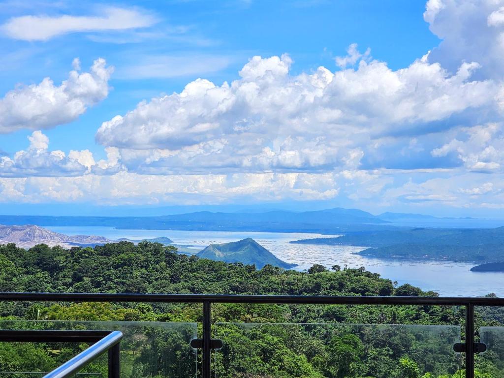 uma vista para um corpo de água com montanhas e árvores em Casa Noah em Tagaytay