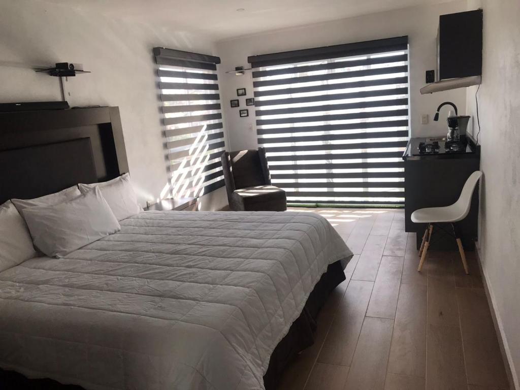 um quarto com uma cama, uma secretária e uma cadeira em el edén em Zacatecas