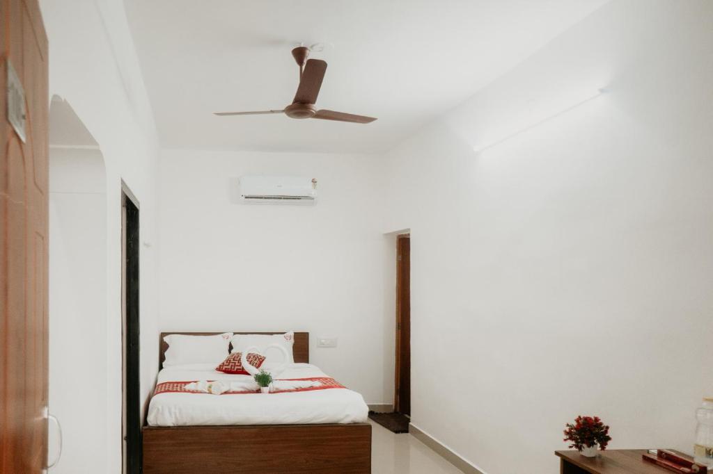 a bedroom with a bed and a ceiling fan at RD VILLA in Perundurai