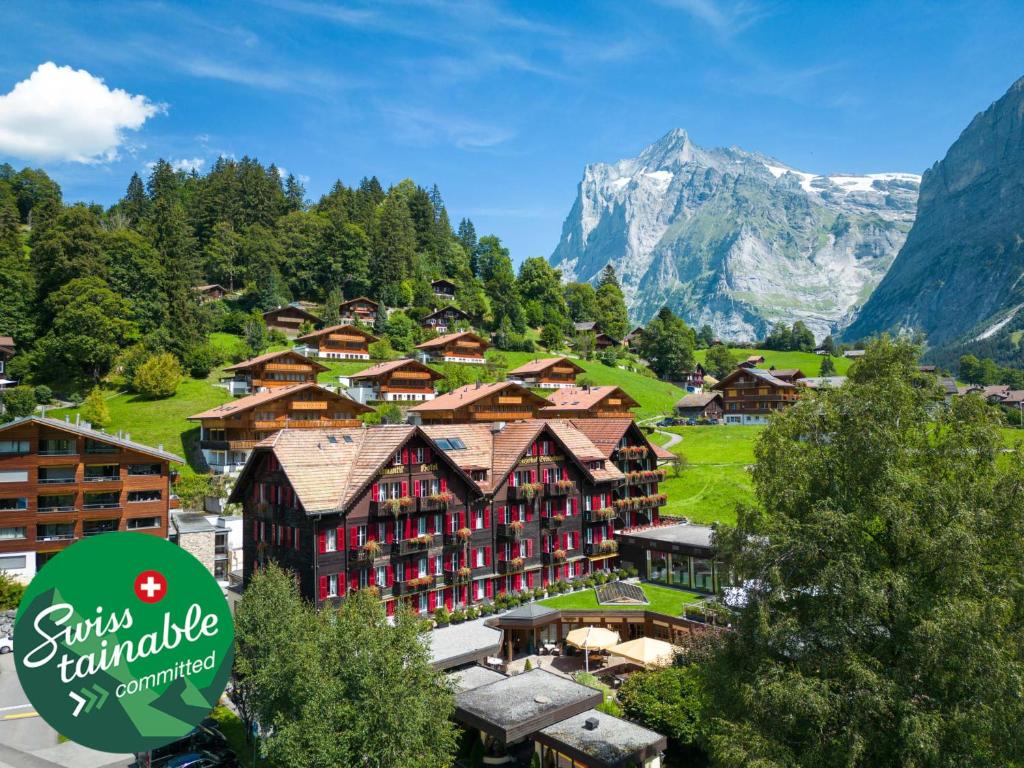 un complexe avec une montagne en arrière-plan dans l'établissement Romantik Hotel Schweizerhof, à Grindelwald