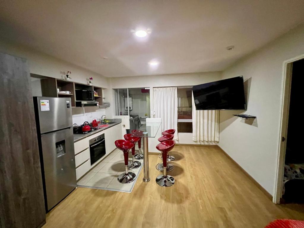 eine Küche mit einem Kühlschrank und zwei roten Stühlen in der Unterkunft Apartamento en Jesús María in Lima