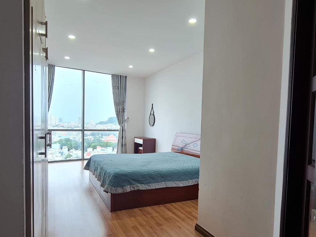 1 dormitorio con cama y ventana grande en Rosemary Homestay, en Vung Tau