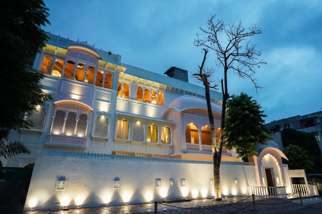 un gran edificio blanco con luces encendidas en Dev Mahal - A Boutique Heritage Hotel, en Jaipur