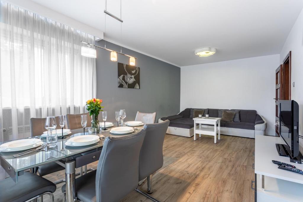 comedor con mesa, sillas y sofá en Apart-Invest Apartament Paryski en Szklarska Poręba