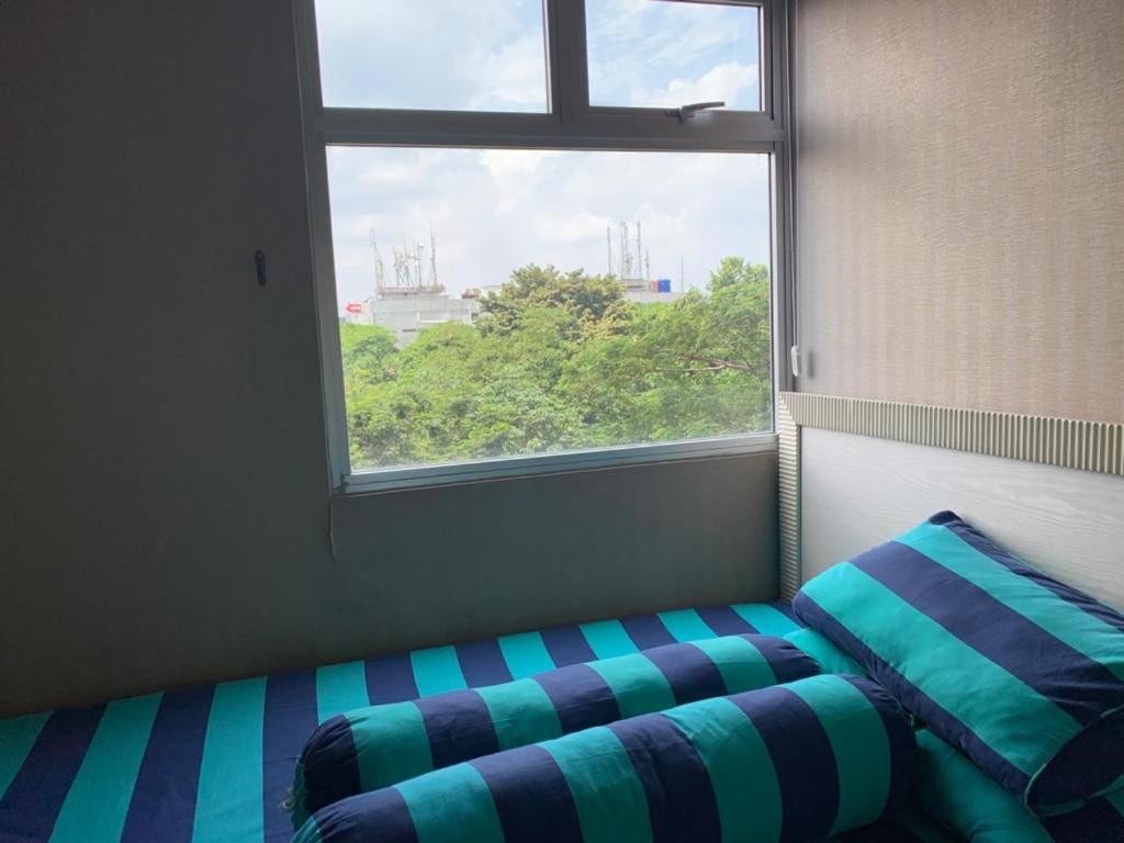 a bed sitting in a room with a window at RrProperty in Jakarta