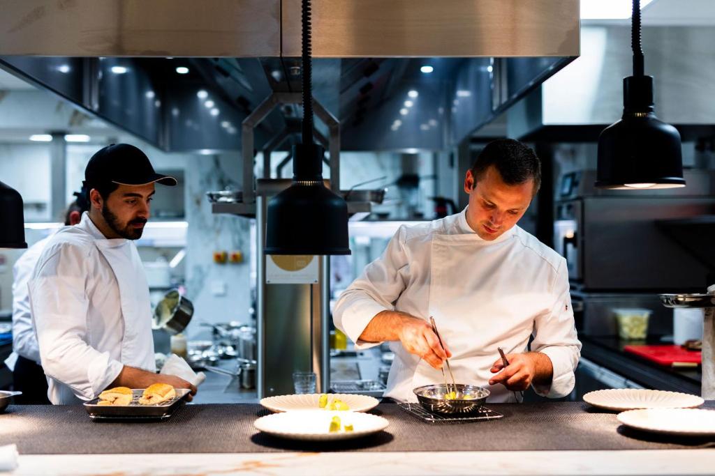 two chefs preparing food in a kitchen at La Bastide Bourrelly - Mathias Dandine in Cabriès