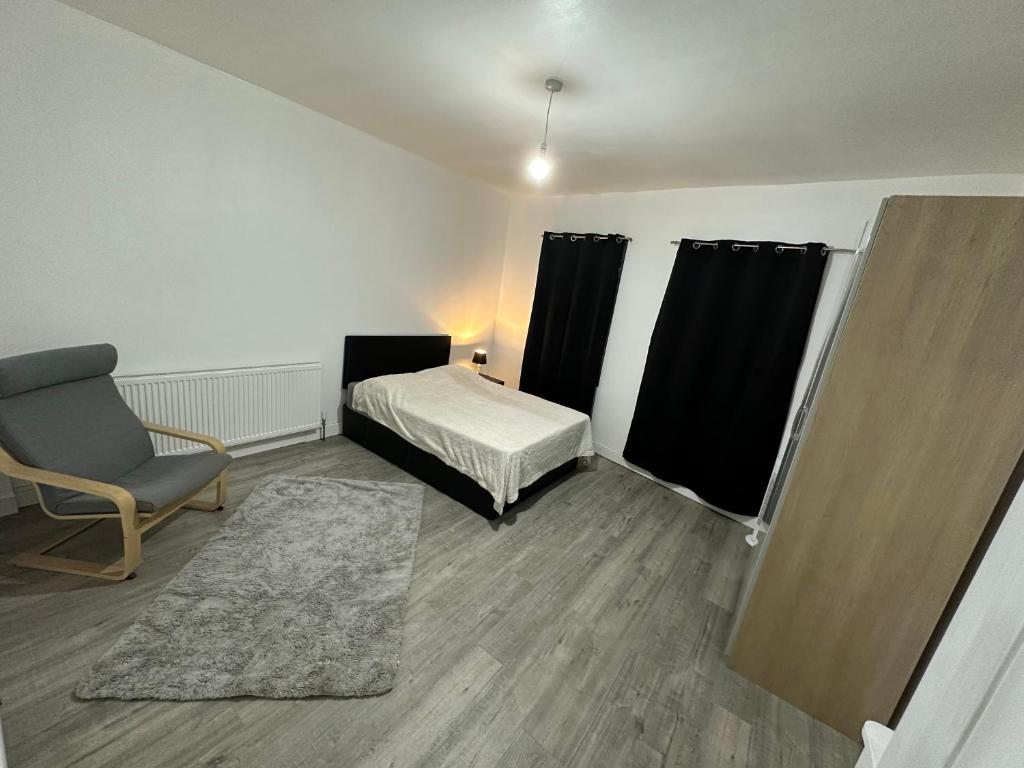 um quarto com uma cama, uma cadeira e uma janela em Luxury apartment on Anfield em Liverpool