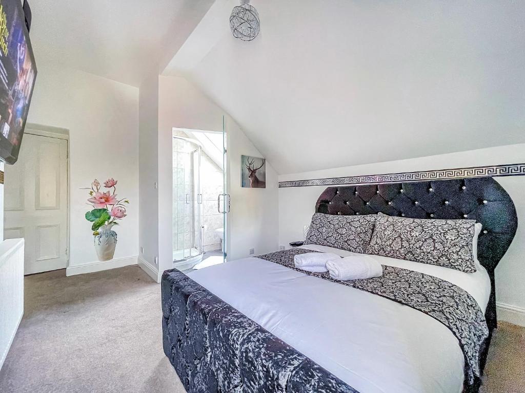 - une chambre avec un grand lit et une tête de lit noire dans l'établissement *RD9bC* For your most relaxed & Cosy stay + Free Parking + Free Fast WiFi *, à Moortown