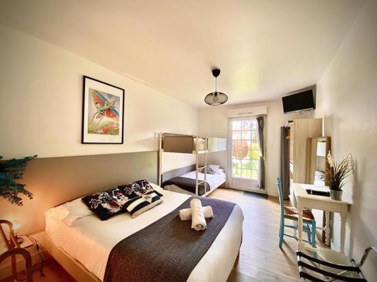 Un dormitorio con una cama con un osito de peluche. en Hotel Aux Rochers de l'Ocean en Givrand