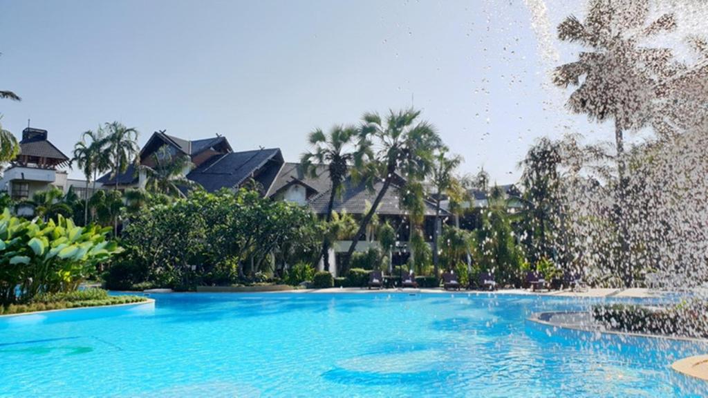 a pool at a resort with a water fountain at Felix River Kwai Resort - SHA Plus,Certified in Kanchanaburi