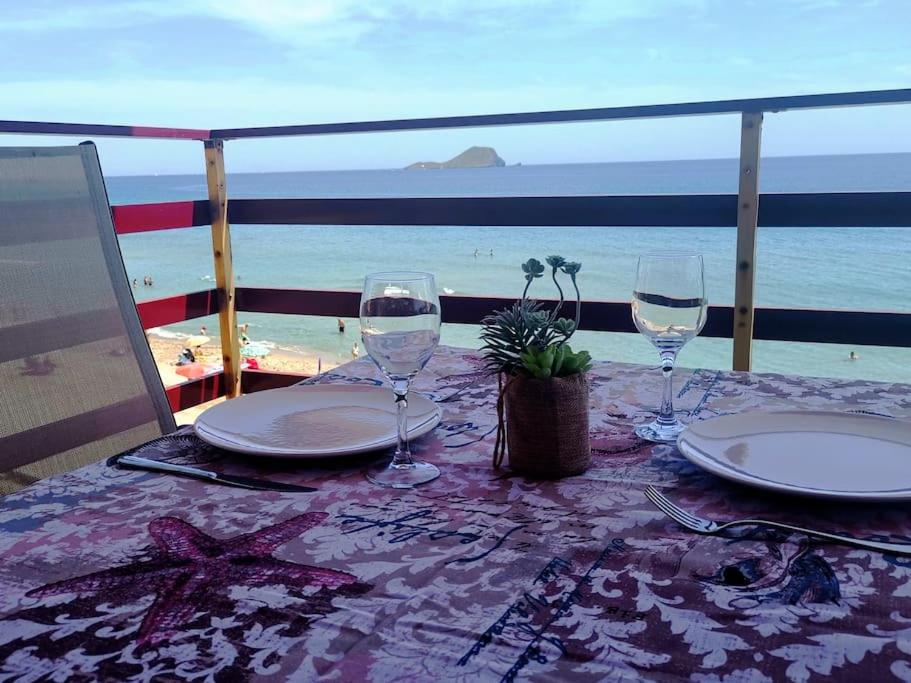 uma mesa com pratos e copos de vinho na praia em Apartamento primera línea La Manga em La Manga del Mar Menor