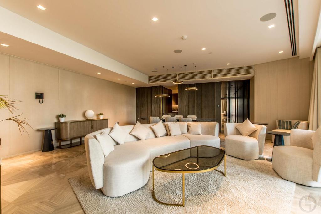 uma sala de estar com um sofá branco e cadeiras em Super Spacious 3BR with Maid's Room in Five Palm em Dubai