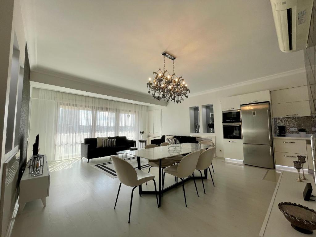 uma cozinha e sala de estar com mesa e cadeiras em Kaplan Luxury Flat - 3 Bedrooms with air conditioning & heating in the City em Istambul