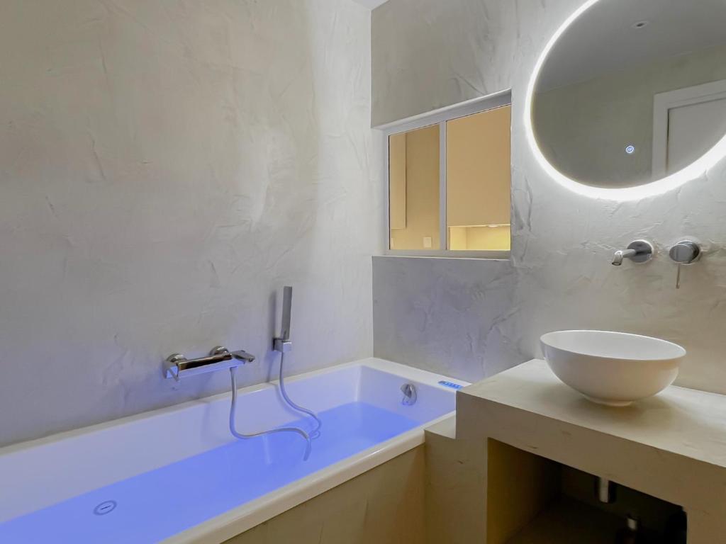 uma casa de banho com uma banheira, um lavatório e um espelho. em Muse old town jacuzzi em Annecy