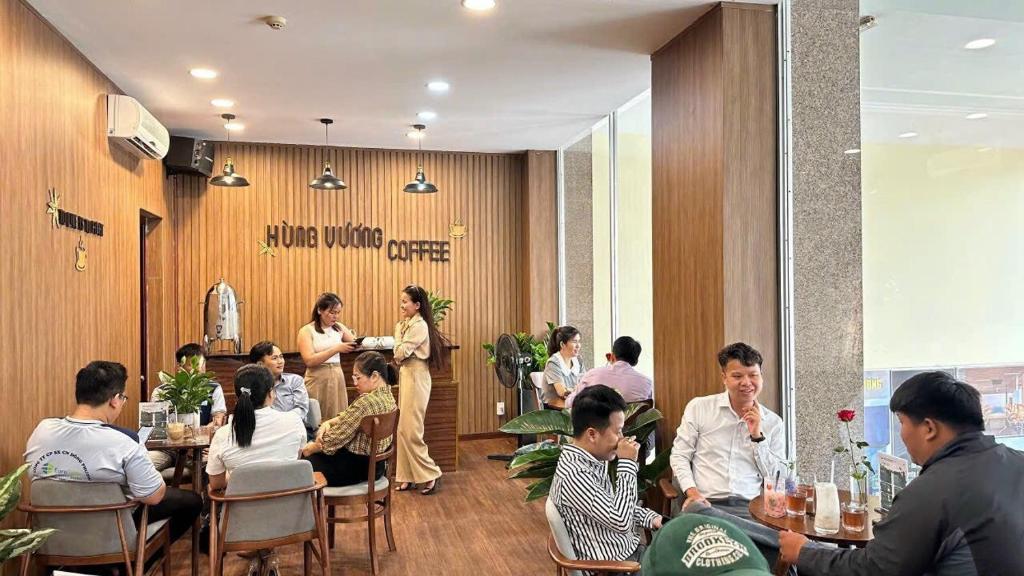 a group of people sitting at tables in a restaurant at Hung Vuong Hotel in Quang Ngai