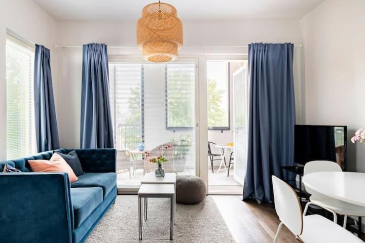 ein Wohnzimmer mit einem blauen Sofa und einem Tisch in der Unterkunft Peaceful Serviced Apartment Tikkurila, near airport, free parking in Vantaa