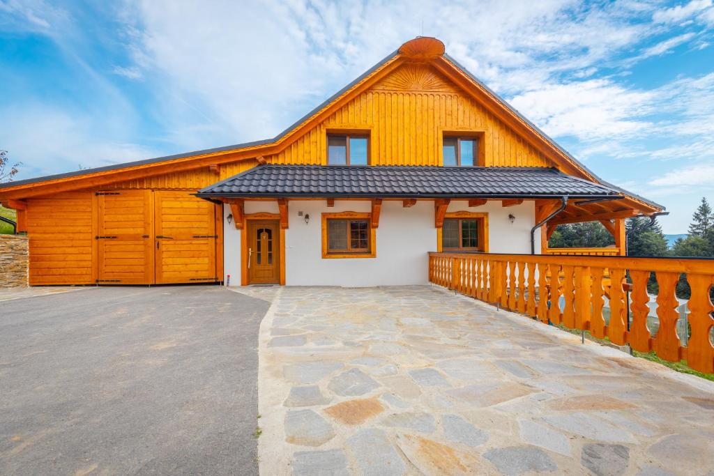 a house with a large driveway in front of it at Wellness Chalupa Benešky in Vsetín