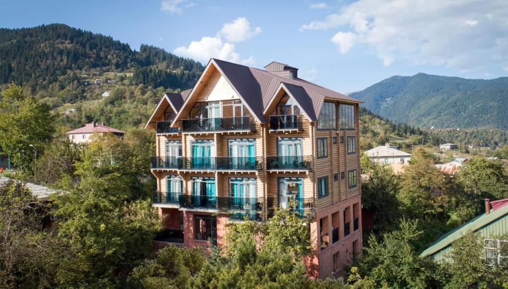 an apartment building with a roof on top of a mountain at Hotel ANNA PALACE in Khulo
