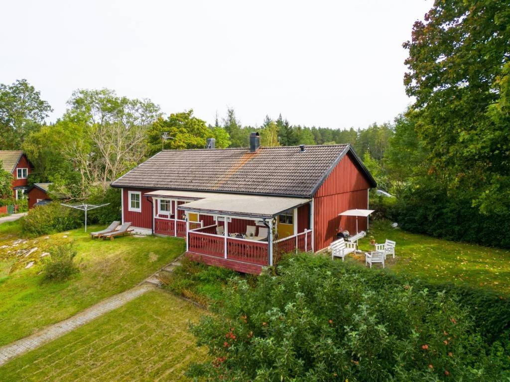 uma casa vermelha com um alpendre e um quintal em A countryside villa close to Uppsala! em Uppsala