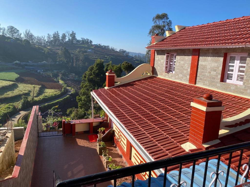 a house with a red roof with a view of a valley at Kanjira house in Ooty