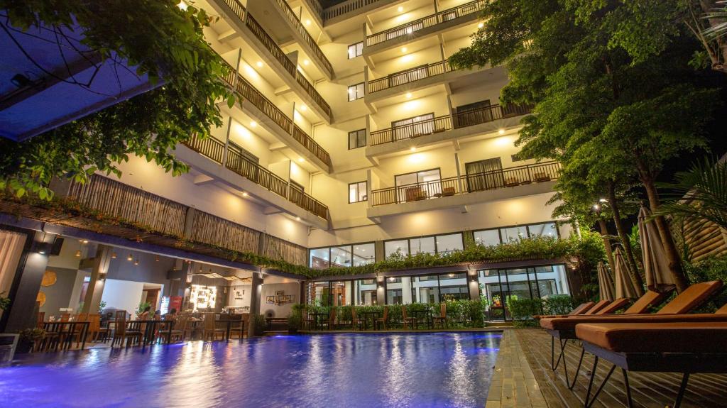een groot gebouw met een zwembad ervoor bij DACO Hotel in Siem Reap