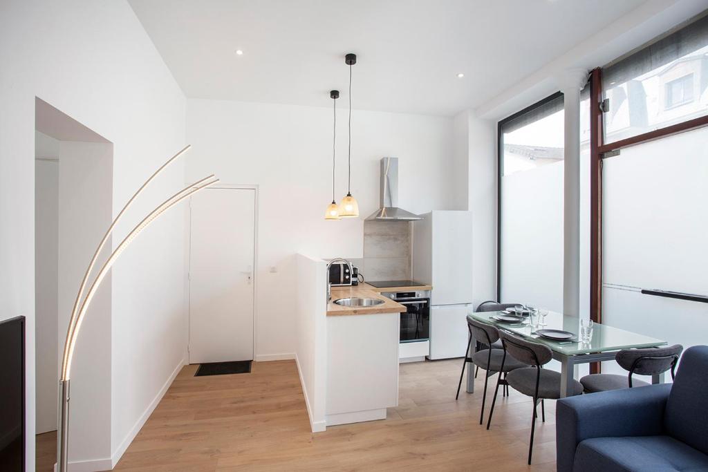 Una cocina y un comedor con mesa y sillas. en Luxury apartment Alfortville, en Alfortville