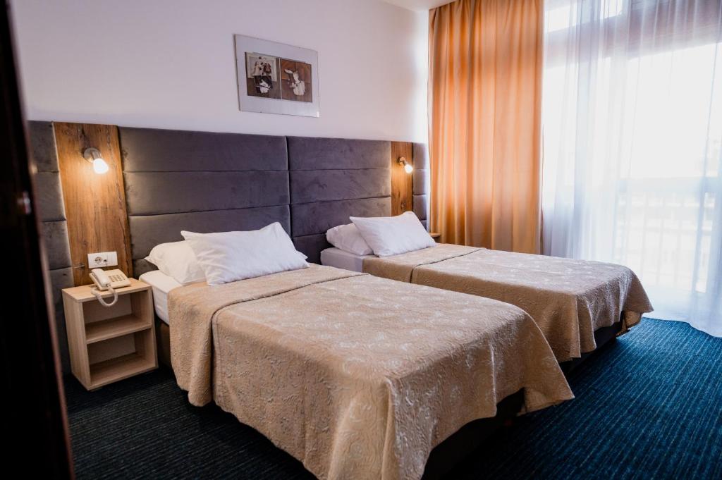 a hotel room with two beds and a window at Hotel Slavija in Belgrade