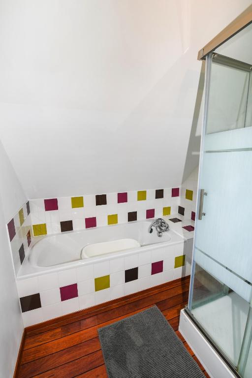 a bathroom with a bath tub in a room at Maison Mélèry in Saint-Pierre-du-Val