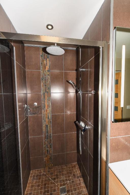 a shower with a glass door in a bathroom at Maison Mélèry in Saint-Pierre-du-Val