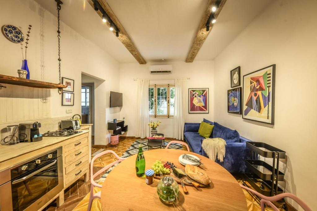 a living room with a table and a blue couch at Rustic 1 BR Apt w Cozy Backyard in City Center by Sea N' Rent in Tel Aviv