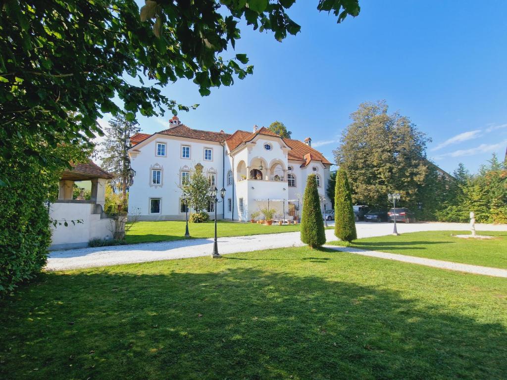 a large white house with a green lawn at Gewerkenschlössl Zeilinger in Knittelfeld